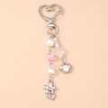 Dettagli di perle di cristallo rosa e ciondoli a cuore su un portachiavi in tono argento - Farfalla Argento Cuore