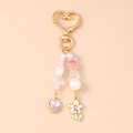 Dettaglio di portachiavi con perline e cristallo rosa a cuore con ciondoli a fiori d'oro - Farfalla Oro Cuore