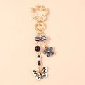 Detailed close-up of cherry blossom clasp and butterfly pendant keychain accessory - Butterfly Flower