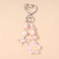 Detail of pink and white striped beads, bow charm, and cherry blossom pendant on keychain - Pink