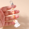 Dettaglio del portachiavi di perle con ciondolo a coniglio e perline in resina arancione - Stile Bottone Ad Anello