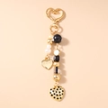 Detailed view of golden heart-shaped clasp and beads with LOVE YOU engraving - Gold