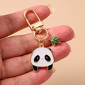 Handheld gold panda keychain with black white enamel pendant and green bamboo leaf charm - Bamboo Panda Keychain