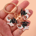 Nahaufnahme des Abschluss-Schlüsselanhängers mit goldenem Ring und Doktorhut-Anhängern - Blumenstrauß Doktorhut