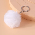 Detail shot of a soft white faux fur pompom keychain with a silver metal link and ring - White