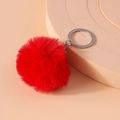 Detail view of a fluffy red faux fur pompom keychain with a polished silver ring - Red