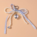 Detalle de llavero con lazo de perlas con cinta de cuadros azules y colgante de corazón - Azul