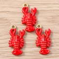 Macro view of three red lobster charms with gold loops on a light wood background - Gold
