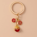 Detail of golden Maneki Neko charm with red lucky coin pendants on metal keychain - Coin Pig Head Keychain