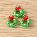 Detail van groene kerstkrans bedeltjes met rode strikken voor DIY sieraden maken accessoires - Kerstkrans Stijl