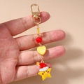 Dettaglio macro della chiusura in metallo e del charm a stella sul portachiavi natalizio - Stile Cuore / Bottone Cuore Stella Cappello Natale