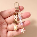 Detail of beaded keychain with starfish, seashell charms and gold carabiner clip - Starfish Shell Beaded Style