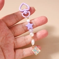 Dettaglio di un portachiavi con perle viola, stelle e ciondolo metallico geometrico - Stile Quadrato con Perla e Stella Viola