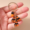 Detailopname van een Halloween-sleutelhanger met gouden ring en emaille bedeltjes - Halloween Huis Sleutelhanger