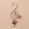 Close-up of a Christmas reindeer keychain with silver metal clasp and a wooden sign pendant - Christmas Reindeer
