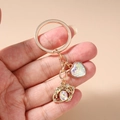 Detail of gold heart keychain with iridescent scales and crystal moon charm - White Heart Eye Keychain