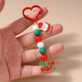 Détail du porte-clés de Noël perlé avec breloques Père Noël et crochet en forme de cœur rouge - Style Pastèque Père Noël
