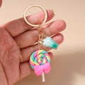 Detailansicht eines farbenfrohen Spiral-Lollipop-Schlüsselanhängers mit rosa Schleife - Grün Eis Lutscher