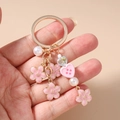 Detailed shot of a floral keychain with cherry blossom charms and pink heart beads - Cherry Blossom Pearl Heart Pink Button
