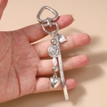 Dettaglio del portachiavi a cuore argento con perla rosa e catena a serpente sulla mano - Catena a Serpente Cuore Perline Fiore