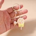 Detailweergave van lolly- en crèmebekerhangers aan een kleurrijke kralen sleutelhanger - Gele Ijslolly