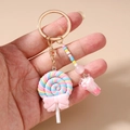 Detail van een lolly-sleutelhanger met macaron-kralen en een gouden metalen ring - Roze Ijslolly