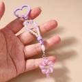 Dettaglio di un portachiavi di perline fatto a mano con clip a cuore viola e stelle - Lecca-Lecca Viola