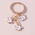 Detail van cartoon vissen sleutelhangers met paarse emaille en gouden ringen - Paars Wit