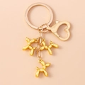 Porte-clés chien ballon doré avec trois pendentifs métalliques et fermoir cœur élégant - Doré