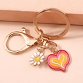 Golden heart keychain with white daisy and oil-painted pink heart pendant on warm background - Daisy Heart Style (爱心)