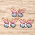 Détail de trois pendentifs papillons en émail avec dégradé rose et bleu et motif nid d'abeille - Lot de 10 / Dégradé Rose Bleu