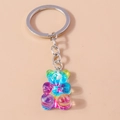 Dettaglio macro di un portachiavi a forma di orso in resina sfumata con anello in metallo - Stile Sfumato Tie-dye / Orso Blu Stellato (蓝色炫彩小熊)