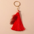 Detailed view of bohemian red feather keychain with elegant silk tassels and gold metal ring - Red