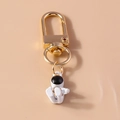 Detail van een gouden D-ring sluiting met een witte astronaut hanger en zwart vizier - Witte Zittende Astronaut Stijl