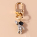 Detail van een retro zilveren astronaut sleutelhanger met gouden sluiting en ster - Grijze Ster Astronaut Stijl