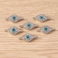 Detail von Hand der Fatima Anhängern mit blauen Strasssteinen für DIY Schmuckherstellung - Doppelring Auge