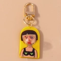 Detailed close-up of cartoon character keychain with gold lobster clasp and yellow acrylic base - Yellow