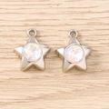 Macro shot of silver star pendants with iridescent rhinestones on a wooden background - Silver Pink