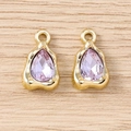 Detailed macro view of two lilac teardrop crystal pendants with wavy gold metal frames - Gold Purple