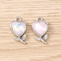 Dettaglio ravvicinato di ciondoli a tulipano a forma di cuore con pietre colorate e metallo - Rosa Argento