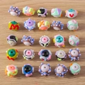 Detailed flat lay of colorful handmade evil eye and letter beads for DIY jewelry making - Mixed Cartoon Letter Beads / 5 Pieces