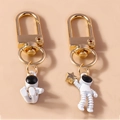 Astronaut-Schlüsselanhänger mit goldenen Sternen und weißen Raumanzügen an Goldkarabinern - Set mit weißen Zirkonia