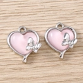 Close-up of pink heart pendants with bow details and silver metal for DIY jewelry - Silver Pink