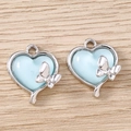 Detail view of heart-shaped blue charms with silver butterfly accents for DIY jewelry - Silver Blue