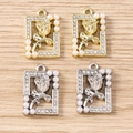 Detail of rose relief pendants with rhinestones and pearls on a wooden surface - Square Artificial Pearl Tulip - Mixed Color / 5 Pieces