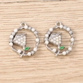 Vista macro dettagliata di due ciondoli floreali in argento con perle e smalto verde deco - Tulipano Perla Tonda - Argento