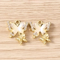Detailed close-up of golden butterfly charms with rhinestones on light wood background - Double Butterfly / 5 Pieces / Gold White