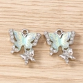 Macro detail of rhinestone butterfly pendants with iridescent green inlay on wood surface - Double Butterfly / 5 Pieces / Silver Blue