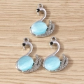 Eleganti ciondoli a cigno con opale blu chiaro e cristalli bianchi su base in legno - Argento Blu Lago