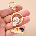 Detailaufnahme von Abschluss-Schlüsselanhänger mit goldenem Blumenstrauß und Doktorhut - Absolvent Hut Rosa Tulpe Schlüsselanhänger